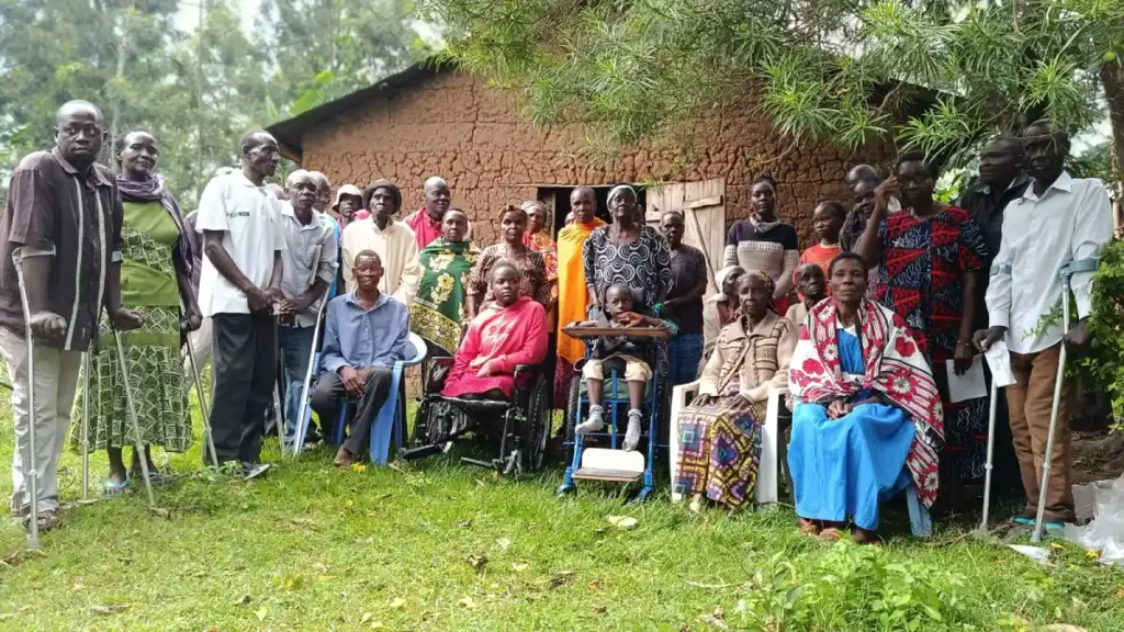 Group photo of persons with disabilities in Bungoma receiving wheelchairs and crutches from DestinyImpact CBO during a community donation event