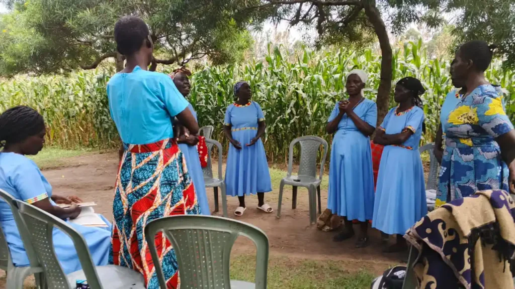 Members of the Wacholi Women’s Group seated together during a regular meeting with the Destiny Impact team, discussing progress and future plans.