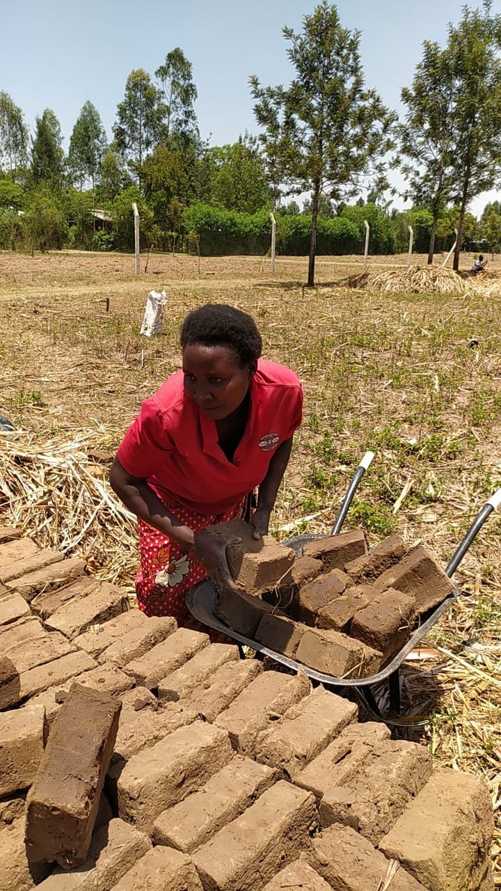 A member of the Annex Women group loading bricks, 2021