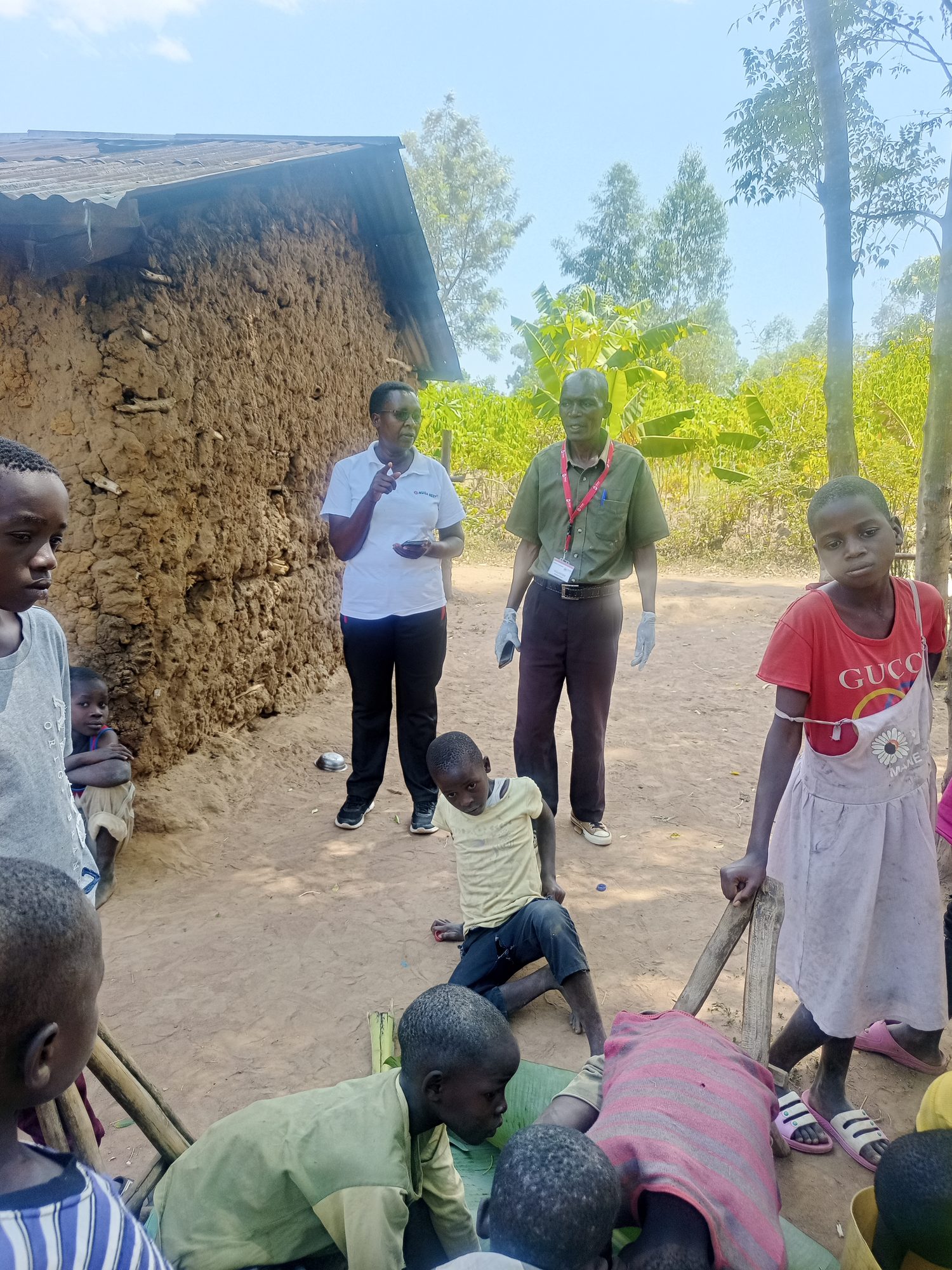 A Destiny volunteer speaking to children during an anti-jigger treatment day