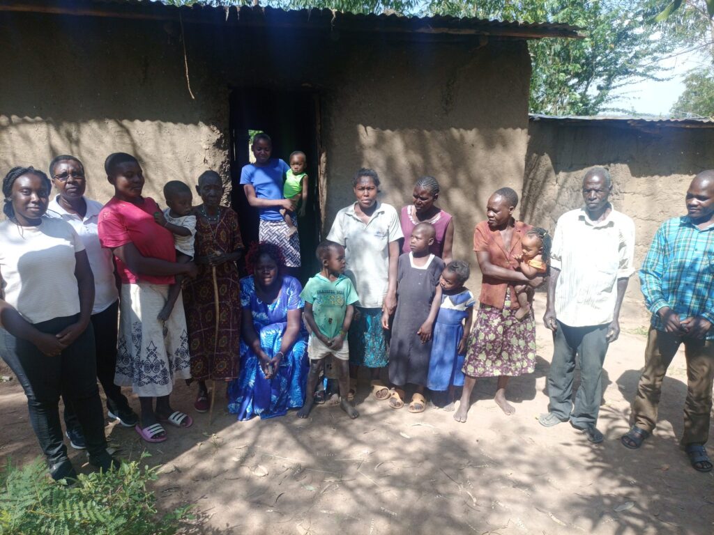 Destiny volunteers with a family and neighbours outside their home