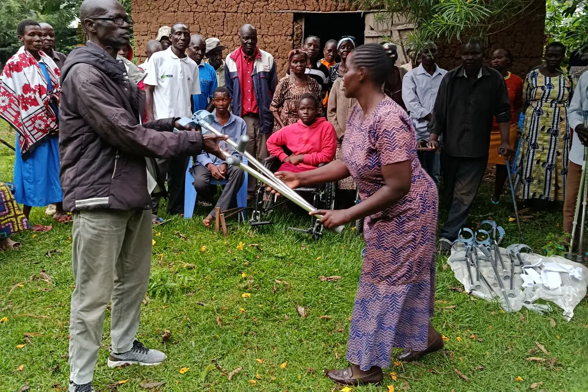 A woman receives a new pair of crutches. Mobility aids donated by NCPWD, handed over at Ng'oli, Bungoma County, 23 August 2025