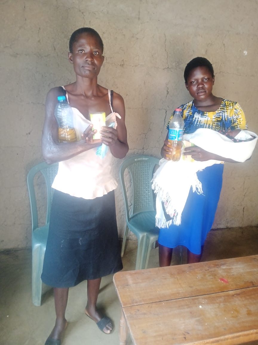 Two women holding cooking oil and supplies donated through Destiny