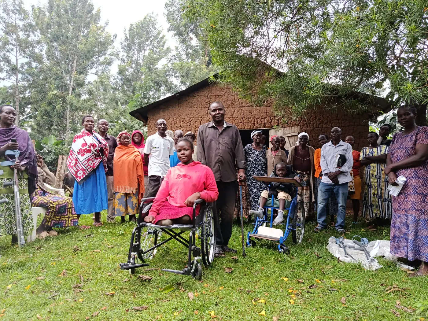 A young woman in a new wheelchair with members of the disability group. Mobility aids donated by NCPWD, handed over at Ng'oli, Bungoma County, 23 August 2025